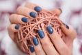 Girl hands with navy blue manicure holding decorative hank