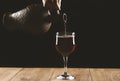 pouring red wine into a glass from a clay bottle on a black background Royalty Free Stock Photo