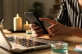 Girl hands using phone on power outage with candles