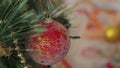 Girl hanging decorative toy ball on Christmas tree