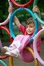 Girl hanging on rings a children's playground