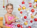 Girl hangs balls on a snowy New Years Christmas tree Royalty Free Stock Photo