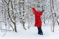 Girl hangs bird feeder in winter snowy forest