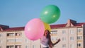 A girl happily poses with large with colorful balloons in the city. Royalty Free Stock Photo