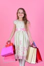 Girl with happy face holds shopping bags on pink background