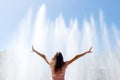 Girl happy sunny day and hands up in the background of the fountain, feeling freedom