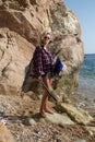 Girl with harpoon in flannel shirt on the rocky beach Royalty Free Stock Photo