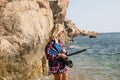 Girl with harpoon in flannel shirt on the rocky beach Royalty Free Stock Photo