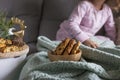 The girl has a delicious chocolate biscuit breakfast. The child is sitting on Dwan. Home comfort and natural light in the photo. Royalty Free Stock Photo