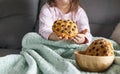 The girl has a delicious chocolate biscuit breakfast. The child is sitting on Dwan. Home comfort and natural light in the photo. Royalty Free Stock Photo