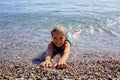 Girl has fun on pebble beach on Geneva Lake, fun, happiness, summer vacations and travel Royalty Free Stock Photo