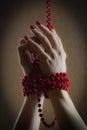 Girl has hands bound with red beads - close up shot - illustrate pretty nail manicure Royalty Free Stock Photo