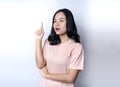 Girl has an idea to solve problem. Pretty Asian woman keeping finger pointed upwards Royalty Free Stock Photo