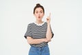 Girl has an idea. Young woman with a solution, raising her finger, suggests something, stands over white background Royalty Free Stock Photo