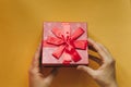 The girl has received a gift in a beautiful red box with a ribbon and is going to open it. Royalty Free Stock Photo