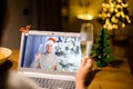 A girl has video call with a guy in santa hat