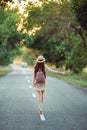 Girl with hat and backpack hitchhiking on the road Royalty Free Stock Photo