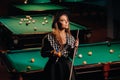 A girl in a hat in a billiard club with a cue in her hands.billiards Game Royalty Free Stock Photo