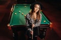 A girl in a hat in a billiard club with a cue in her hands.Pool Game Royalty Free Stock Photo