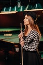 A girl in a hat in a billiard club with a cue in her hands.Pool Game Royalty Free Stock Photo