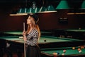 A girl in a hat in a billiard club with a cue in her hands.Pool Game Royalty Free Stock Photo