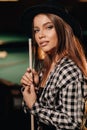 A girl in a hat in a billiard club with a cue in her hands.Pool Game Royalty Free Stock Photo