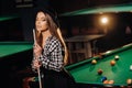 A girl in a hat in a billiard club with a cue in her hands.Pool Game Royalty Free Stock Photo