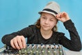 The girl in the hat controls the music mixing console winking at the viewer Royalty Free Stock Photo