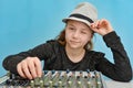 The girl in the hat controls the music mixing console winking at the viewer