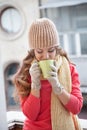 The girl in the hat froze and drinking hot tea Royalty Free Stock Photo