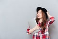 Girl in hat holding laptop and looking away at copyspace Royalty Free Stock Photo