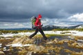 A girl in a hat jumps over bumps among the water on a snowy lawn Royalty Free Stock Photo