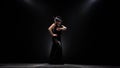 Flamenco. Girl is dancing a Spanish incendiary dance. Black background. Llight from behind