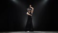 Flamenco. Girl dancing a Spanish incendiary dance. Black background. Llight from behind. Slow motion