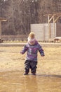 girl in a hat and overalls enters a large dirty pool