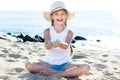 Baby girl in hat playing with sand on sea coast in summer Royalty Free Stock Photo