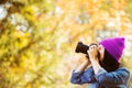 Girl in hat with professional camera on fall season park Royalty Free Stock Photo