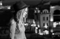 Girl with hat in profile against night city background Royalty Free Stock Photo