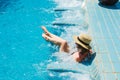 Girl in hat relaxing in spa swimming pool jacuzzi, enjoying vacation. Luxuty lifestyle, healthy feet, skin care concept.