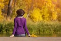 Girl in a hat sits on the dock and admires the colors of autumn. Royalty Free Stock Photo