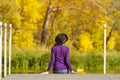 Girl in a hat sits on the dock and admires the colors of autumn. Royalty Free Stock Photo