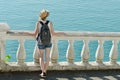 Girl in hat standing on the balcony and looking at the sea. Back Royalty Free Stock Photo