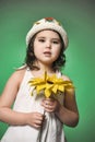 Girl in a hat in the studio on a green background with sunflower Royalty Free Stock Photo
