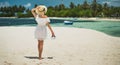 A girl in a hat and white dress is walking along the beach. White sand beach. Maldives, island of Guraidhoo. Girl on vacation. Par Royalty Free Stock Photo