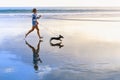 Girl have fun with dachshund dog, run by sea beach Royalty Free Stock Photo