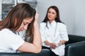 Girl have mental breakdown and crying. Young woman have a visit with female doctor in modern clinic Royalty Free Stock Photo