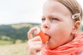 Girl having asthma using asthma inhaler outdoors Royalty Free Stock Photo