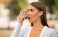 Girl Having Asthmatic Attack Using Inhaler Walking In City