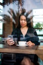 Girl having coffee and using phone in the bar Royalty Free Stock Photo