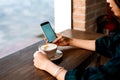 Girl having coffee and using phone in the bar Royalty Free Stock Photo